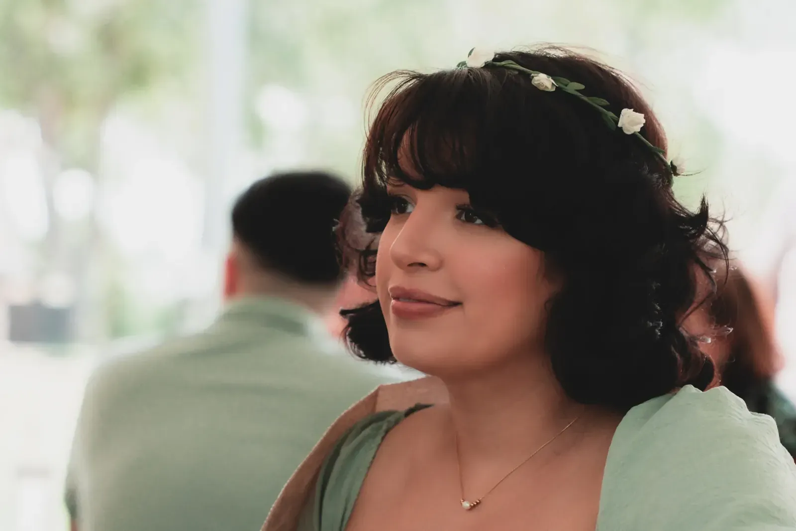 Baby shower guests sharing a laugh near floral arrangements.